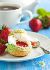 Profiteroles with strawberry compote and whipped cream.