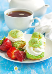 Profiteroles with strawberry compote and whipped cream.