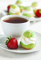 Profiteroles with strawberry compote and whipped cream.