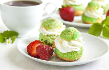 Profiteroles with strawberry compote and whipped cream.