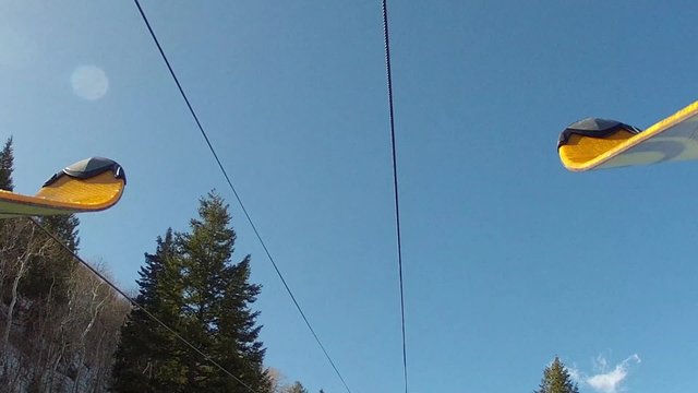 skis and boots riding up a ski lift