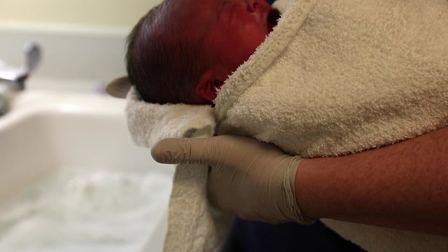 a newborn being bathed after birth at a hospital