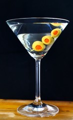 Clear alcoholic cocktail with three olives