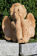 Ceramic sculpture of a sitting Angel.