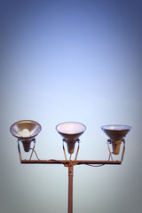 Three projectors of light against the sky background 