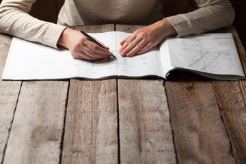 Fototapeta premium woman holding a pen over a house blueprint