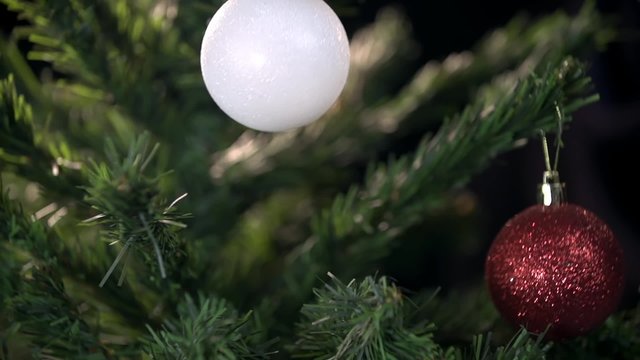 Decorative ball hanged on shiny Christmas tree