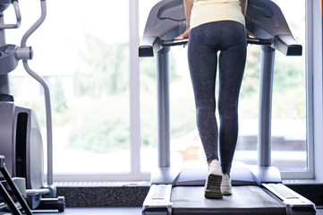 Fototapeta na wymiar Back view of a girl on treadmill