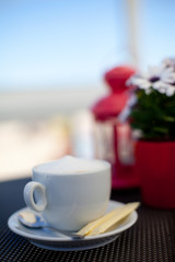 Cup of coffee on the balcony in front of the sea