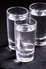 Three glasses of vodka, black and white, selective focus