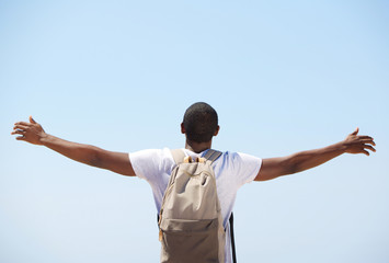 Young black man standing with arms outstretched