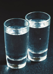 Two glasses of gin on a dark background, black and white, select