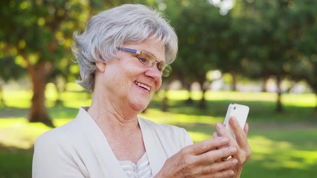 Senior woman taking selfies at the park