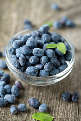 Honeysuckle berries in bowl on wooden surface