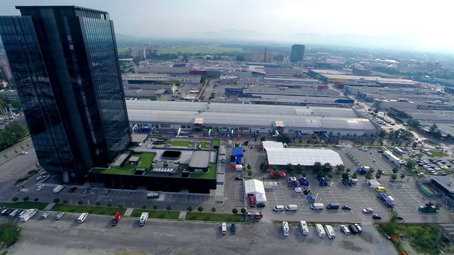 Aerial of skyscraper and bikers bellow preparing for competition