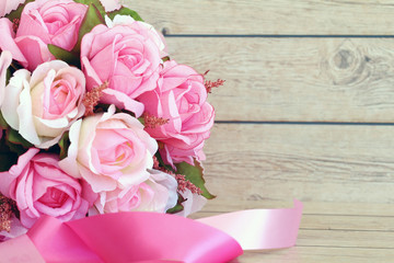 Pink roses against a wood wall
