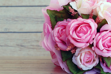 Pink roses against a wood wall