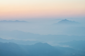 Fototapeta premium Scenery view of the mountains in the mist layer background. View from Phu Chi Fah in Chiang Rai province of Thailand.