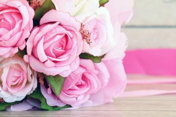 Pink roses against a wood wall