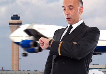 Handsome airline worker looking at his watch