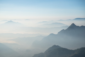 Scenery view of the mountains in the mist layer background. View from Phu Chi Fah in Chiang Rai province of Thailand.