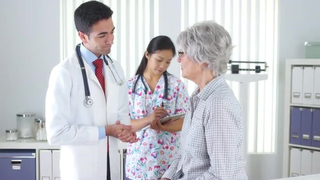 Hispanic doctor talking with elderly patient