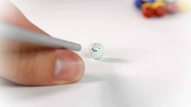 Preparing to hit a smiling face in pool table on white backround