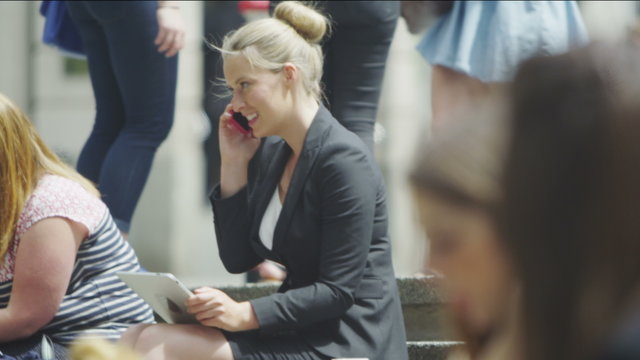 Business woman sitting in a crowd working in slow motion