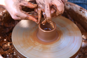 Hands working on pottery wheel