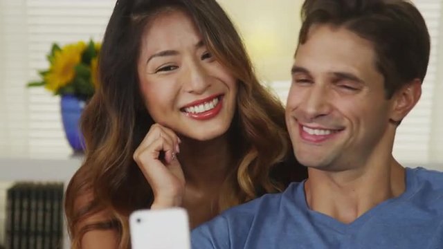 Happy interracial couple taking selfies