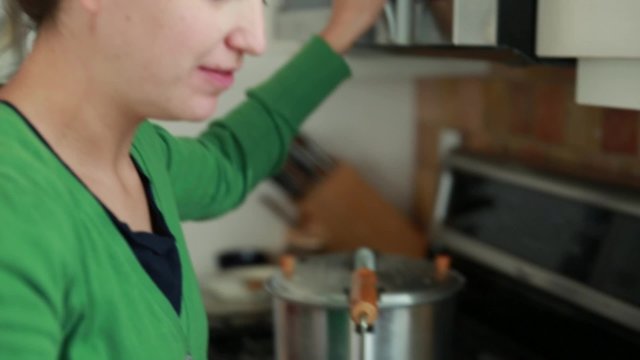 A Woman Making Popcorn In The Kitchen