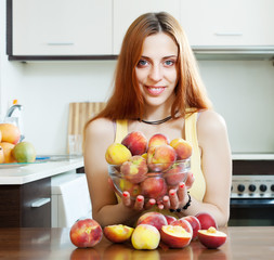 Positive houswife holding peaches