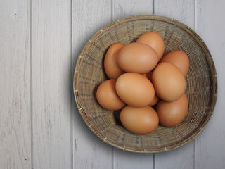 Fresh eggs in basket on wooden background