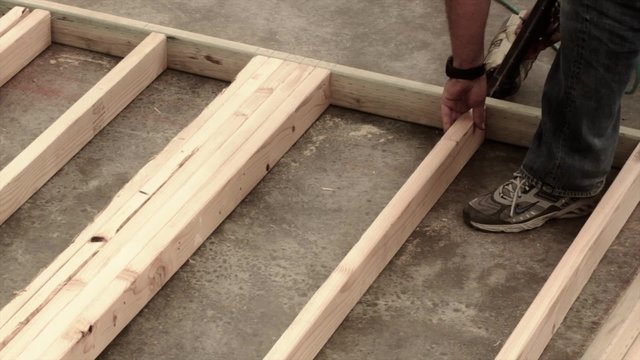 Builder constructing a wall with nail gun