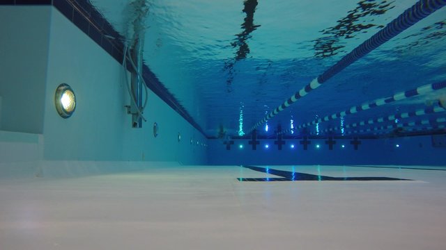 An underwater shot of man swimming freestyle in a pool