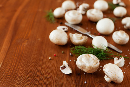 Cultured mushrooms champignons on wooden rustic background