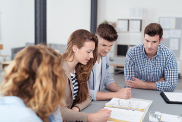 gruppe studenten sitzt am tisch und bespricht die unterlagen