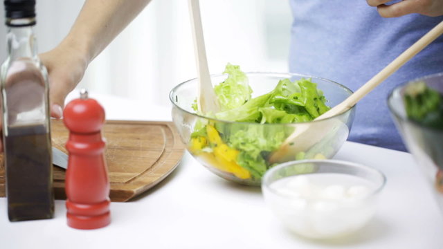 close up of woman cooking vegetable salad at home