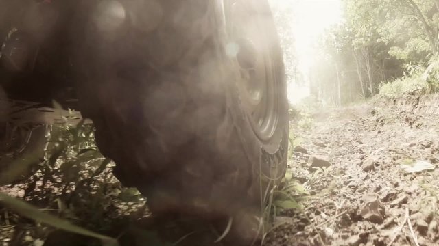 low shot of a tire on four wheeler traveling on a dirt road