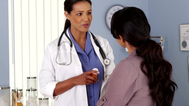 Black doctor explaining prescription medicine to female patient