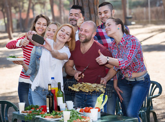 Naklejka na ściany i meble Adults doing selfie at picnic