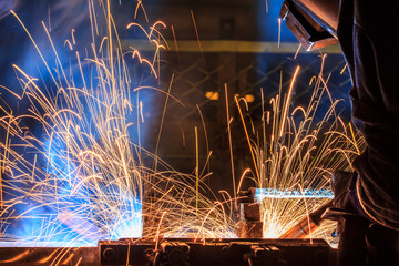 welder with protective equipment in factory