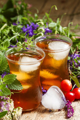 Ice black tea with herbs, selective focus