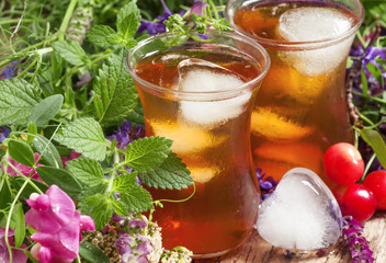 Ice black tea with herbs, selective focus