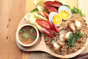 Instant noodles soup put crispy pork and egg