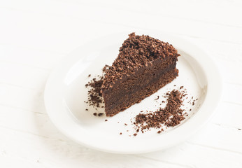 piece of chocolate cake on a white plate on a light background