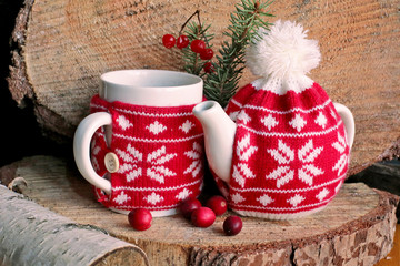 Tea knitted pot with  cup  and berries