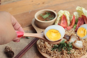 Instant noodles soup put crispy pork and egg