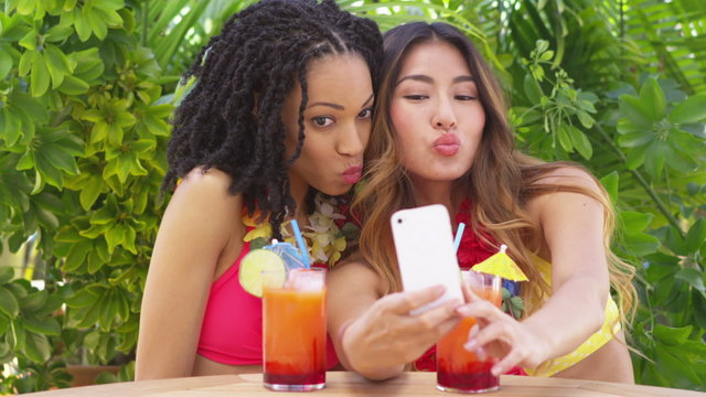 Two best friends taking selfie while on tropical vacation