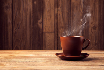 warm cup of coffee on brown background